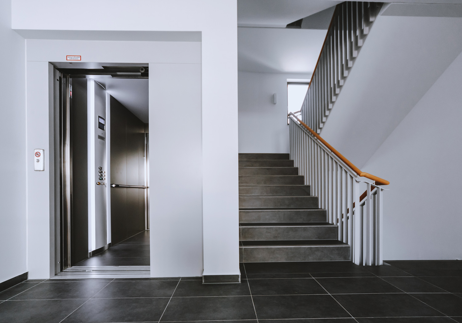 Modernes Treppenhaus mit Aufzug, barrierefreier Zugang und zeitgem&auml;&szlig;e Ausstattung in Wohn- oder Gesch&auml;ftshaus.