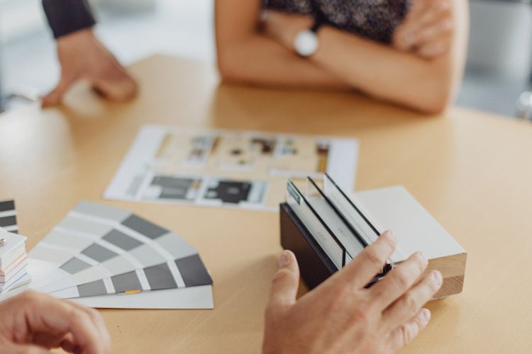 Farb- und Materialauswahl bei Planungsgespräch, Design- und Innenarchitekturberatung am Tisch.