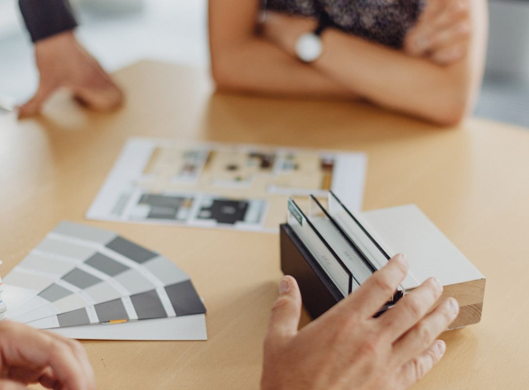 Farb- und Materialauswahl bei Planungsgespräch, Design- und Innenarchitekturberatung am Tisch.